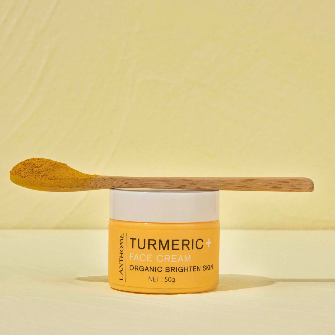 Turmeric+ Face Cream jar from Lanthome on Rosvia, topped with a wooden spoon filled with turmeric powder.